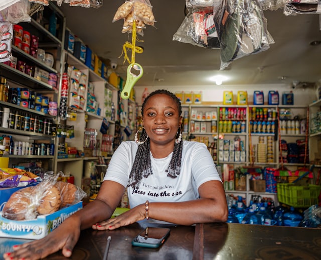 Shop owner behind the counter of a well-stocked retail store